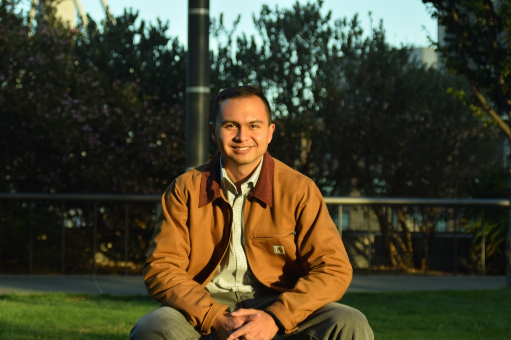 Ayden Salazar at golden hour, wearing a tan Carhartt jacket, sitting in a park